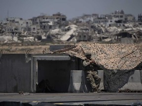 Seorang prajurit Angkatan Darat AS berdiri di samping tempat berlindung di dermaga terapung Trident buatan AS dengan latar belakang pantai Jalur Gaza, Selasa, 25 Juni 2024.