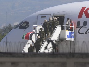 Polisi dari Kenya turun dari pesawat di Bandara Internasional Toussaint Louverture di Port-au-Prince, Haiti, Selasa, 25 Juni 2024. Kontingen polisi asing pertama yang didukung PBB tiba hampir dua tahun setelah negara Karibia itu meminta bantuan untuk meredam lonjakan pengungsi. kekerasan geng.