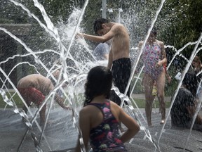 People cool off in the fountain at Polk Brothers Park