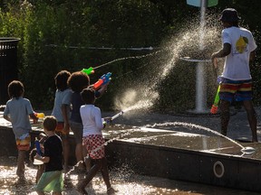 Children play with water guns at a splash pad