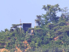 A facility (centre) believed to be North Korean loudspeakers are seen at the top of a hill in North Korea as viewed from South Korea's Ganghwa Island near the Demilitarized Zone (DMZ) dividing the two Koreas on June 11, 2024.