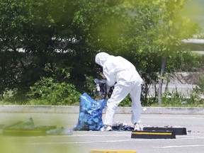 An officer wearing protective gear collects the trash