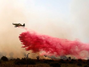 A firefighting aircraft releases flame retardant to extinguish fires caused by rockets launched from southern Lebanon which landed on the outskirts of Safed, in the upper Galilee, on June 12, 2024.