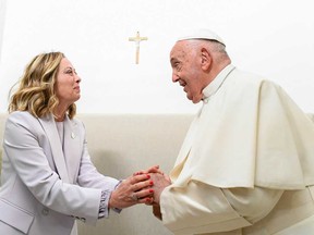 This photo taken and handout on June 14, 2024 by The Vatican Media shows Italy's Prime Minister Giorgia Meloni welcoming Pope Francis in Savelletri during the G7 Summit at the Borgo Egnazia resort.