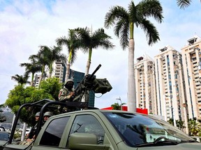 Mexican army infantry soldiers aboard military trucks patrol the streets in the tourist port of Acapulco, Guerrero state, Mexico during a security operation in the face of a growing wave of violence on June 20, 2024.