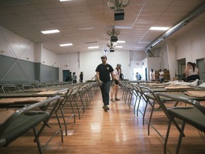 Volunteers unload and set up cots at the Dennis Drolet Memorial Hall ahead of the arrival of evacuees from Fort Good Hope, in Norman Wells, N.W.T. on Saturday, June 15, 2024. Residents of Fort Good Hope, N.W.T., are being told to evacuate due to a wildfire burning less than two-kilometres from the community.