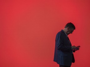 FILE - A visitor looks at his phone at the Mobile World Congress 2024 in Barcelona, Spain, Feb. 27, 2024. According to some un-scientific studies, the average person has hundreds of passwords to their name.
