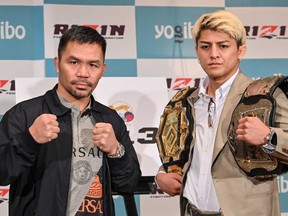 Retired multiple world boxing champion Manny Pacquiao of the Philippines (left) and Japanese kickboxer Chihiro Suzuki pose during a photo session at the end of a press conference at a hotel in Tokyo on June 10, 2024.