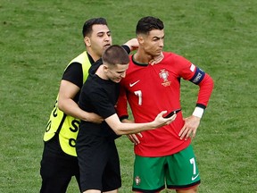 A pitch invader takes a selfie photograph with Portugal's forward Cristiano Ronaldo during the UEFA Euro 2024 Group F football match between Turkey and Portugal at the BVB Stadion in Dortmund on June 22, 2024.