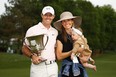 Rory McIlroy of Northern Ireland celebrates with the trophy alongside his wife Erica and daughter Poppy after winning the 2021 Wells Fargo Championship at Quail Hollow Club on May 9, 2021 in Charlotte, N.C.