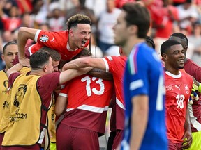 Switzerland's midfielder Ruben Vargas (top left), Switzerland's forward Kwadwo Duah (right) celebrate at the end of the UEFA Euro 2024 round of 16 football match between Switzerland and Italy at the Olympiastadion Berlin in Berlin on June 29, 2024.