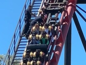 Screenshot of two Canadas Wonderland employees tending to passengers stuck on The Bat roller coaster on June 15, 2024.