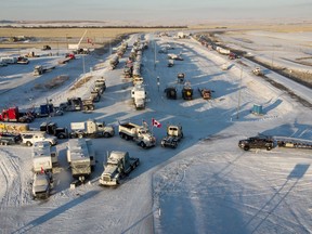 A truck convoy of anti-COVID-19 vaccine mandate demonstrators block the highway at the busy U.S. border crossing in Coutts, Alta., Wednesday, Feb. 2, 2022.