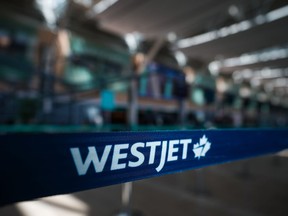 Um logotipo da WestJet é visto na área de check-in doméstico no Aeroporto Internacional de Vancouver, em Richmond, BC, na sexta-feira, 19 de maio de 2023.