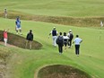 Japan's Aguri Iwasaki (L) reacts after playing from a green-side bunker onto the 8th green during practice ahead of the 152nd British Open Golf Championship.