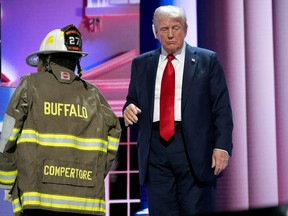 Republican presidential nominee, former U.S. President Donald Trump walks near the firefighter uniform of Corey Comperatore as he speaks on stage on the fourth day of the Republican National Convention at the Fiserv Forum on July 18, 2024 in Milwaukee, Wisconsin.