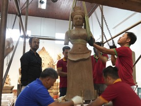 Museum staff members prepare an artifact returned from U.S to Cambodia