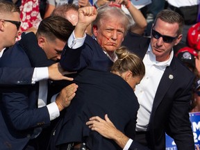 Se ve a Donald Trump con sangre en el rostro rodeado de agentes del Servicio Secreto cuando lo sacan del escenario luego de un tiroteo en un evento de campaña en Butler, Pensilvania, el sábado 13 de julio de 2024.