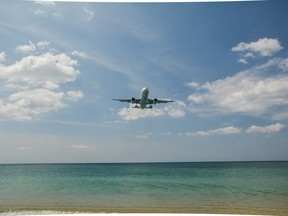 Plane flies over the sea to land at the airport