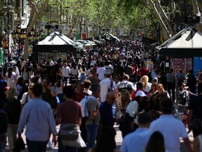 Tourists walk up and down Las Ramblas alley in Barcelona on April 13, 2024.