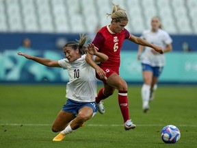 New Zealand's Indiah-Paige Riley, left, and Canada's Cloe Lacasse vie for the ball during the women's Group A soccer match between Canada and New Zealand at Geoffroy-Guichard stadium during the 2024 Summer Olympics, Thursday, July 25, 2024, in Saint-Etienne, France.