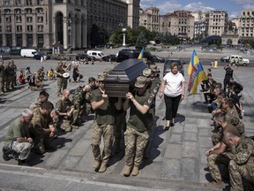 Ukrainian servicemen carry the coffin of British combat medic Peter Fouche