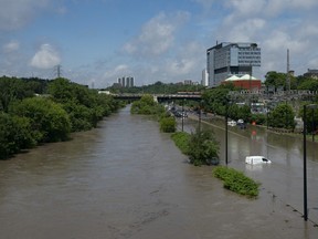 The Don River spills its banks, causing flooding on surrounding roads.