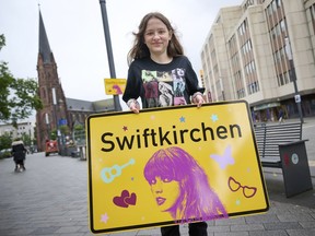 Schoolgirl Aleshanee Westhoff shows a "Swiftkirchen" town sign