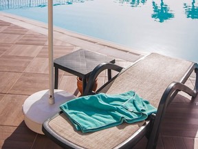 Sun-lounger and towel at a pool.