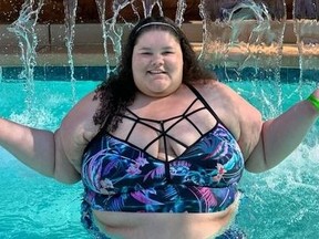 Plus-size travel influencer Jaelynn Chaney under waterfall in swimming pool.