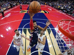 ফিলাডেলফিয়া 76ers' টোবিয়াস হ্যারিস, কেন্দ্রে, মঙ্গলবার, 21 নভেম্বর, 2023, ফিলাডেলফিয়ায় এনবিএ বাস্কেটবল ইন-সিজন টুর্নামেন্ট খেলার প্রথমার্ধে ক্লিভল্যান্ড ক্যাভালিয়ার্সের ডিন ওয়েড, বাম, এবং জর্জেস নিয়াং-এর মধ্যে শট খেলতে যাচ্ছেন৷