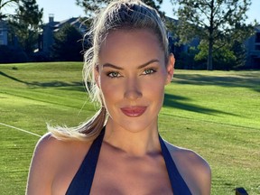 Paige Spiranac usando uma regata frente única em um campo de golfe.