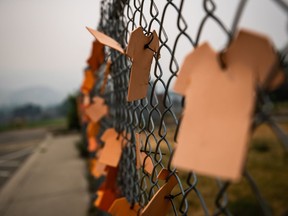 A First Nation community in northern Manitoba says ground-penetrating radar has found 150 anomalies at and around the site of a former residential school, along with 59 unmarked graves at a nearby cemetery. Cutouts of orange T-shirts are hung on a fence outside the former Kamloops Indian Residential School, in Kamloops, B.C., on Thursday, July 15, 2021.