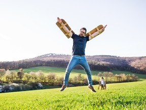 Menino feliz brincando lá fora com o pai na natureza da primavera.