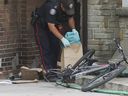 A Toronto police officer collects evidence from inside a home following a basement fire in Toronto's west end on Wednesday, Aug. 28, 2024.