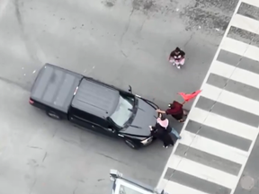 A screengrab from video posted to X of protesters impeding a pickup truck in downtown Toronto on Tuesday, Aug. 6, 2024.