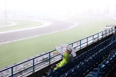 Spectators try to stay dry during Saturday's King's Plate at Woodbine. The event was ultimately washed away and will now be held on Friday.