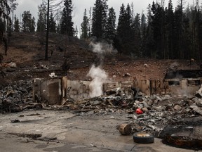Os restos de uma casa fumegante em Jasper, Alta., na sexta-feira, 26 de julho de 2024.