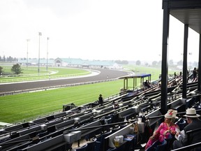 La gente se sienta en las tribunas del Woodbine Racetrack después de que un fuerte aguacero provocara la cancelación de parte del King's Plate, en Toronto el sábado 17 de agosto de 2024.