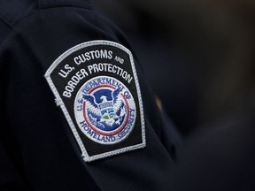 FILE - A customs agent wears a patch for the U.S. Customs and Border Protection agency, Oct. 27, 2017, at John F. Kennedy International Airport in New York.