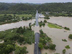 La Plata river overflows onto a road after Tropical Storm Ernesto passed through Toa Baja, Puerto Rico, Wednesday, Aug. 14, 2024.