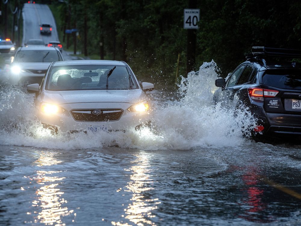 Los automóviles circulan lentamente por las calles inundadas en Sainte-Anne-de-Bellevue, en la isla de Montreal, después de que las fuertes lluvias azotaran la zona el viernes 9 de agosto de 2024. Hoy se esperan más aguaceros fuertes en Montreal y otras partes de Quebec que aún se están recuperando. debido a las lluvias récord de hace nueve días.