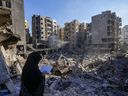 Una mujer lee el Corán en el lugar del asesinato del líder de Hezbolá, Hassan Nasrallah, en los suburbios del sur de Beirut, el domingo 29 de septiembre de 2024.