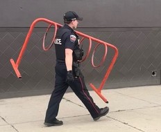 A Hamilton Police officers carries a bike rack stolen from a McDonald's.