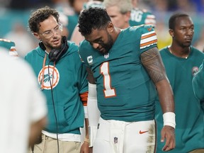 El entrenador en jefe de los Miami Dolphins, Mike McDaniel, habla con el mariscal de campo Tua Tagovailoa.
