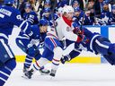 Nick Robertson (izquierda) de los Toronto Maple Leafs tiene un asiento en primera fila mientras su compañero Jake McCabe (derecha) sufre lo peor de esta colisión con Owen Beck (62) de los Montreal Canadiens durante la acción de hockey de la NHL de pretemporada del tercer período en Toronto el jueves. 26 de septiembre de 2024.