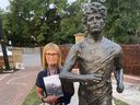 Glemena Bettencourt holds a new book about Terry Fox while standing beside the statue of the Marathon of Hope runner in Richmond Hill,. Wednesday Sept. 4, 2024.
