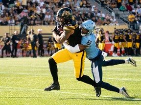 El receptor abierto de los Hamilton Tiger-Cats, Brendan O'Leary-Orange (4), es abordado por el back defensivo de los Toronto Argonauts, DaShaun Amos (8) durante la acción de la CFL en Hamilton, Ontario, el lunes 2 de septiembre de 2024. Amos definitivamente ha tenido nariz para el fútbol en 2024. El veterano back defensivo de los Toronto Argonauts ha registrado siete robos de balón, el mejor de la CFL (cinco intercepciones, dos recuperaciones de balón suelto) en lo que va de la temporada.
