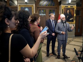 El diputado del NDP, Peter Julian, observa mientras el líder Jagmeet Singh habla con los periodistas en el vestíbulo de la Cámara de los Comunes, el jueves 19 de septiembre de 2024 en Ottawa.
