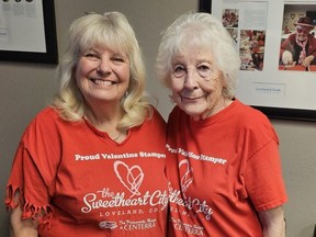 Volunteer valentine stampers Jeanne Perrine (left) and Joyce Boston pose inside the visitors centre in Loveland, Colo.